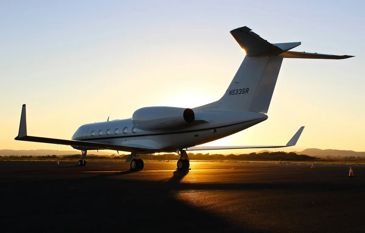 Large-cabin business jet on the ramp at sunset